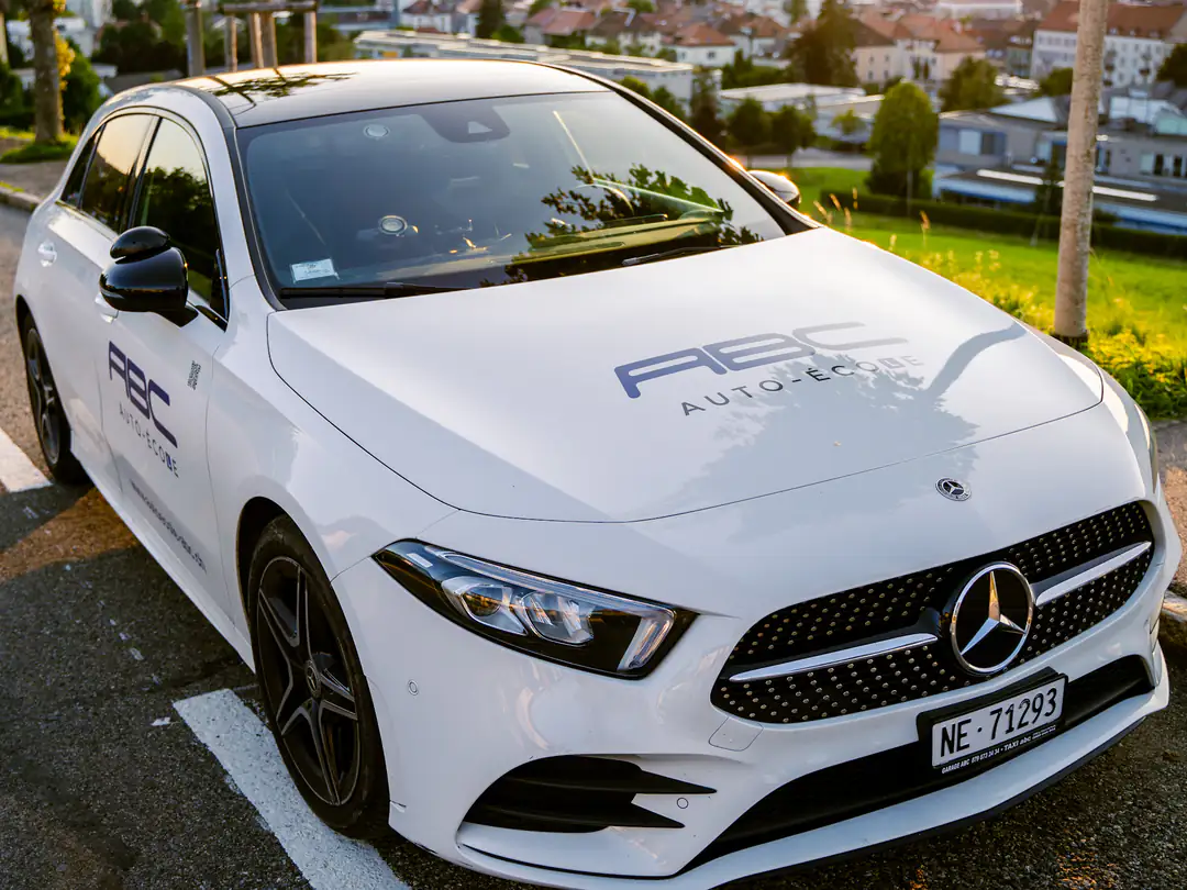 La voiture-école de l'Auto-école ABC, une Mercedes Classe A blanche, au-dessus de La Chaux-de-Fonds